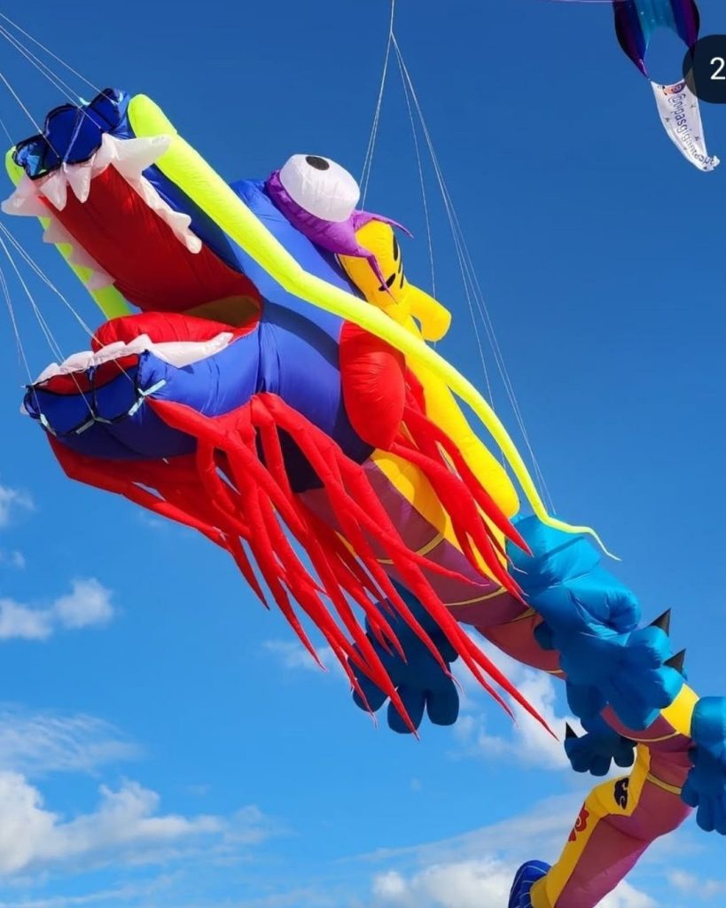 Pipa gigante em forma de dragão colorido no céu azul