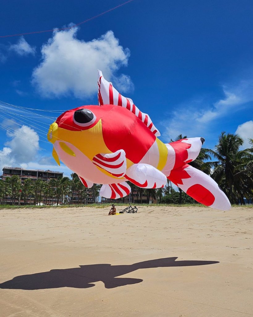 Pipa gigante em forma de peixe vermelho na praia
